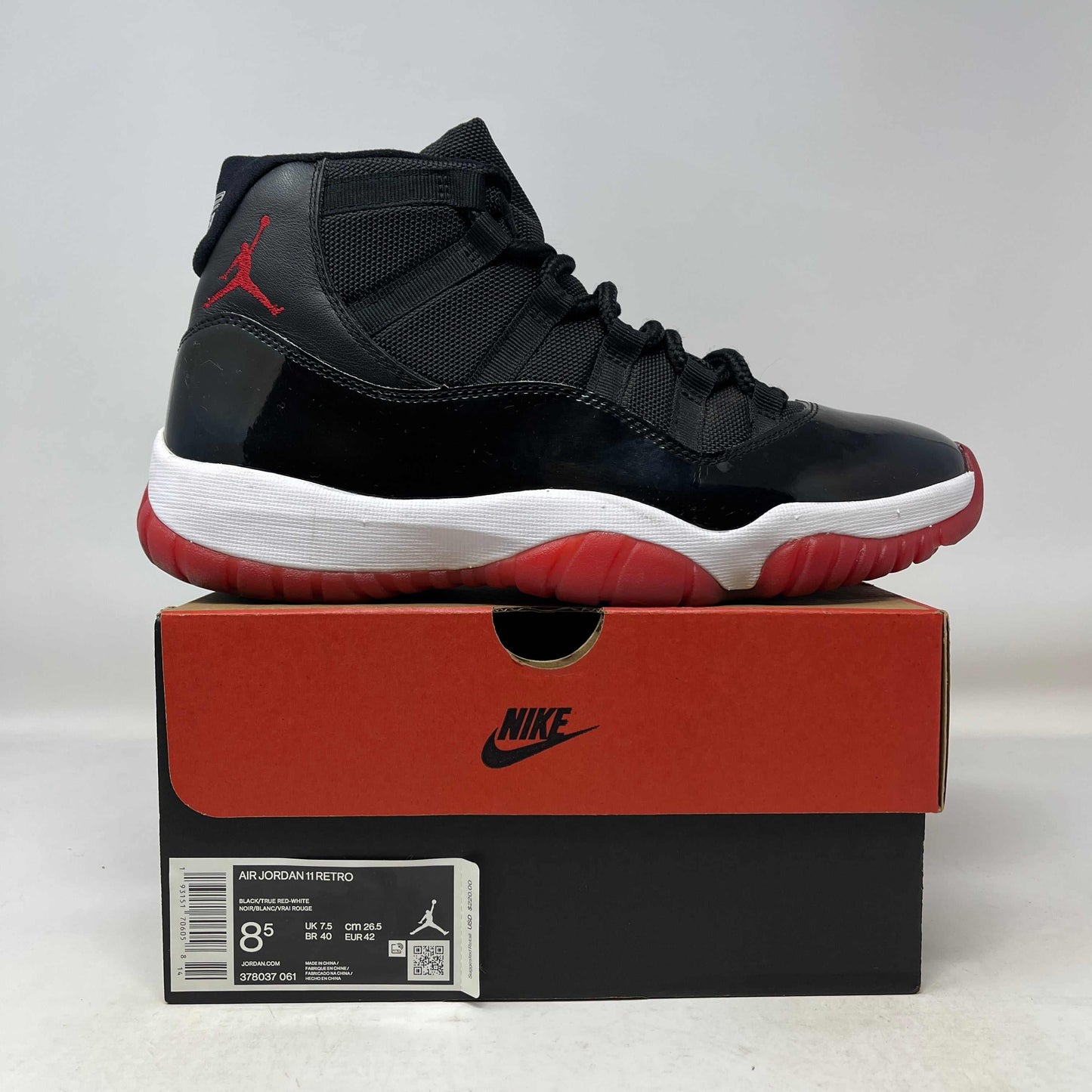 Used Jordan 11 Retro Playoffs Bred (2019) sneaker on Nike box, black and red design with white sole