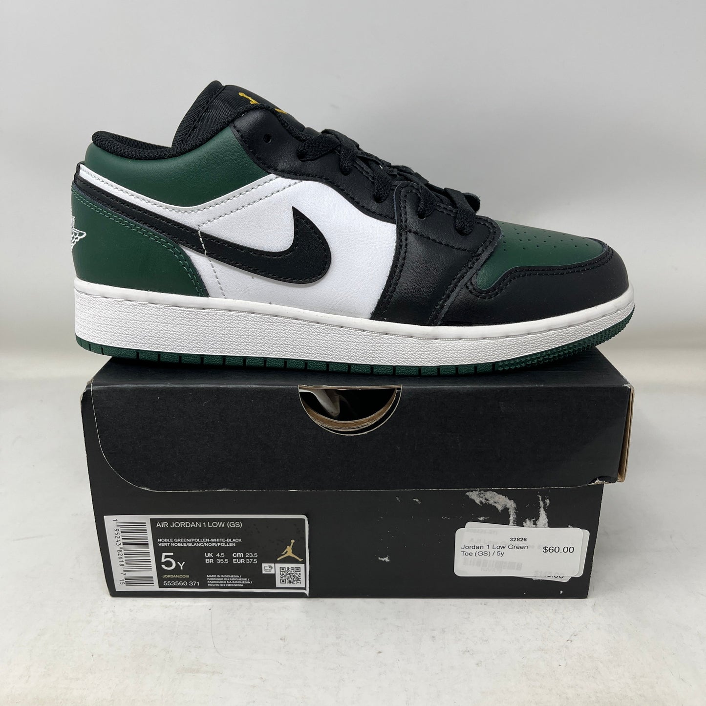 Side view of Jordan 1 Low Green Toe GS sneaker on black box with green, white, and black colorway