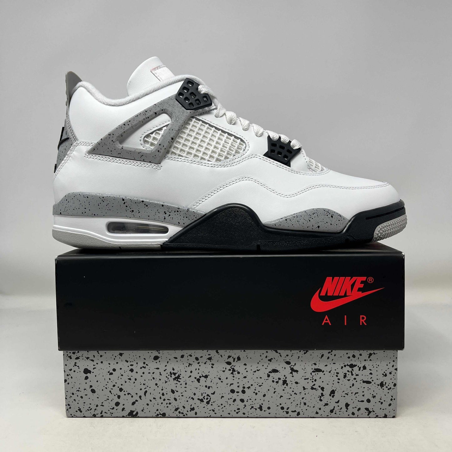 Jordan 4 Retro White Cement sneaker 2025 edition on Nike Air box with speckled cement detailing
