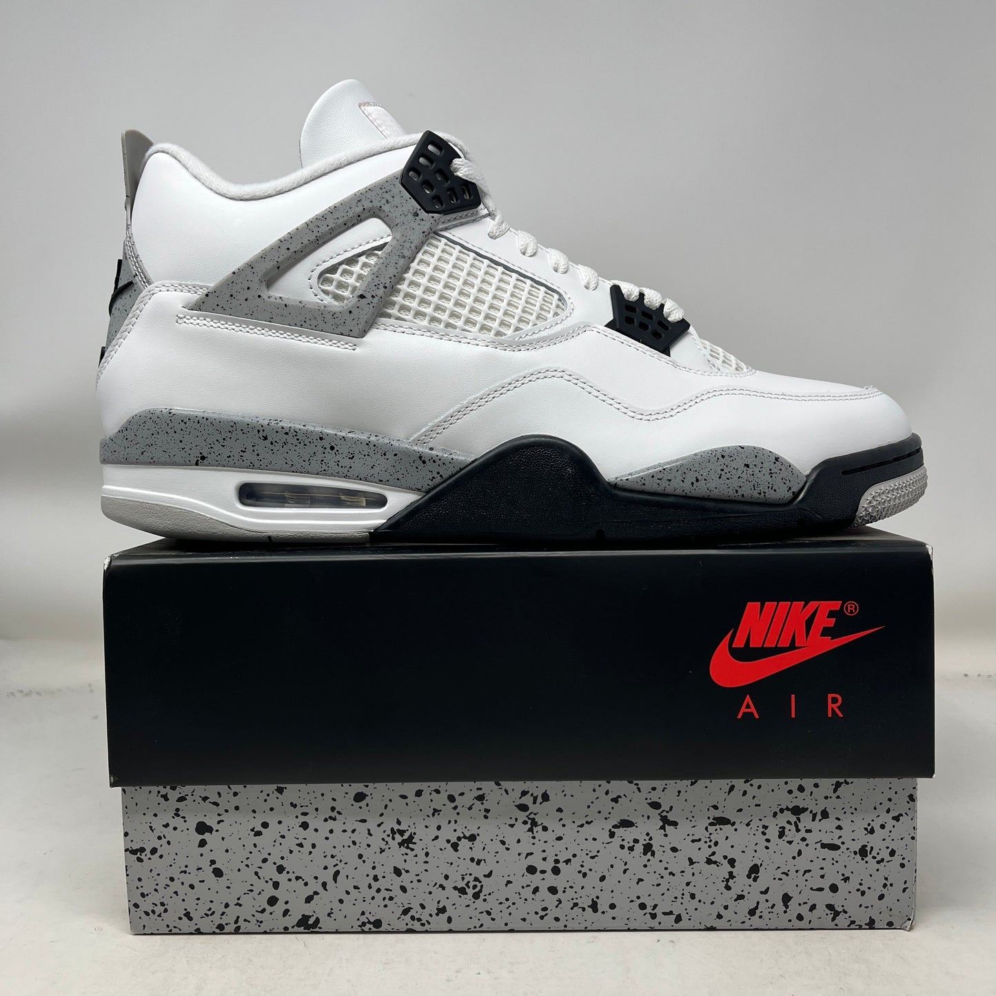 Air Jordan 4 Retro White Cement 2025 sneaker with white leather, speckled grey accents, black and fire red details