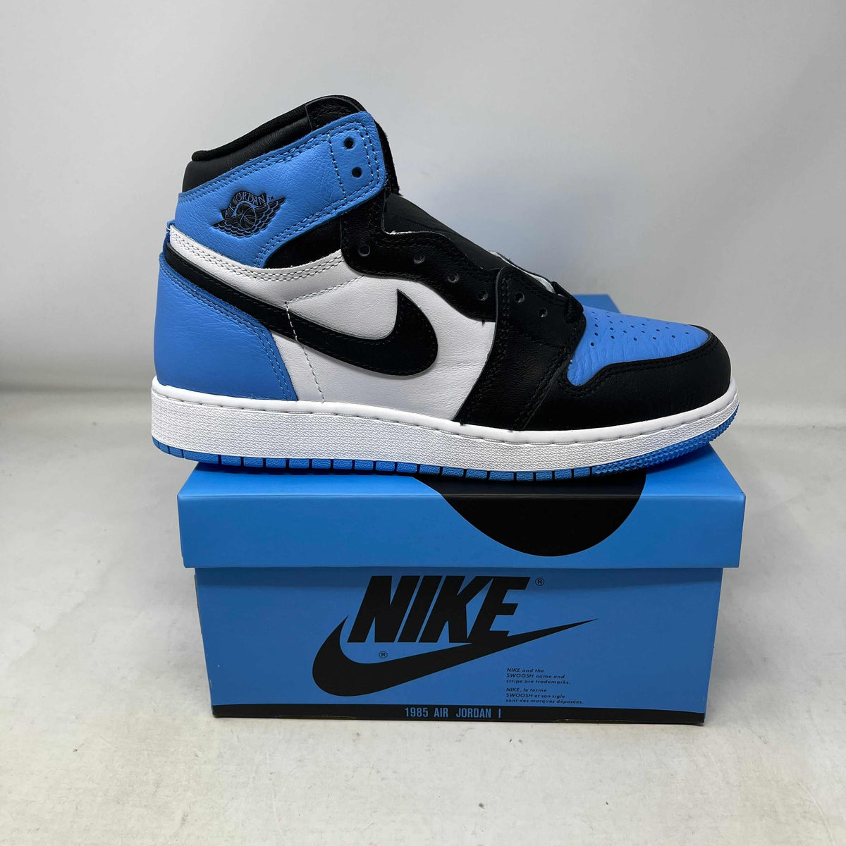 High-top Jordan 1 Retro High OG UNC Toe sneaker in blue, white and black leather, with a perforated toe and Swoosh.