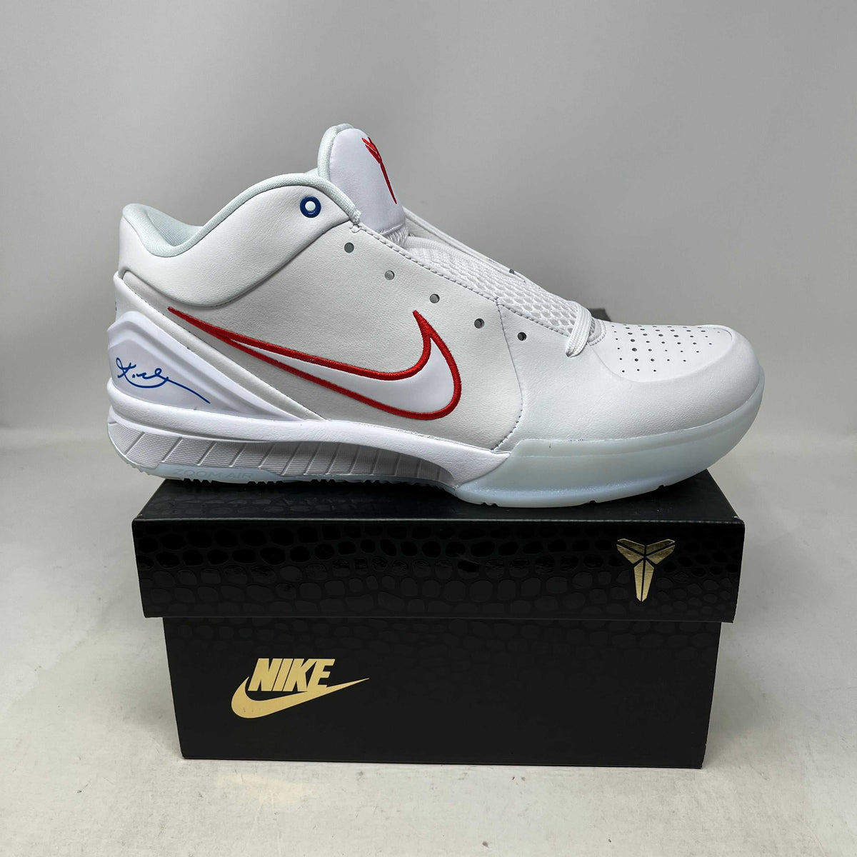 Nike Kobe 4 Protro Draft low-top basketball sneaker in white leather with a red outlined Swoosh, blue signature, and perforated toe.