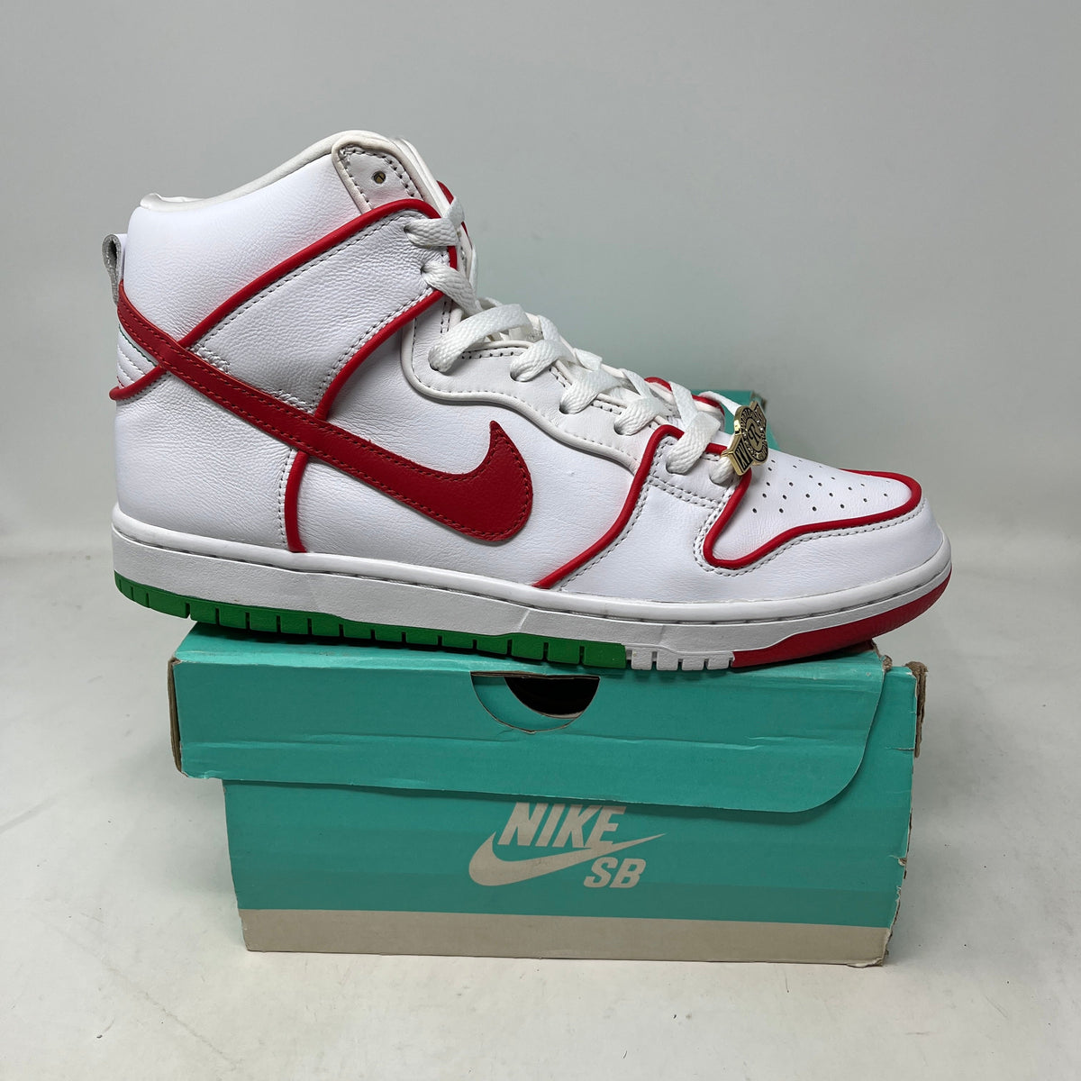 Nike SB Dunk High Paul Rodriguez Mexico sneaker in white leather with red piping, a red swoosh, green outsole accents, and gold lace dubrae.