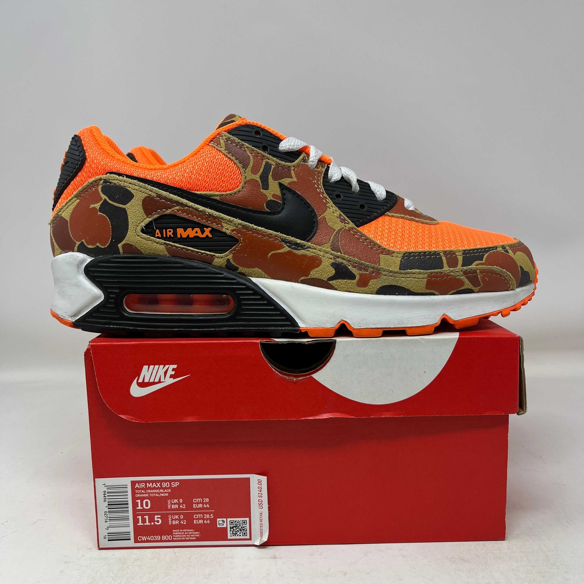 Used Nike Air Max 90 sneaker in duck camo orange design on red Nike box