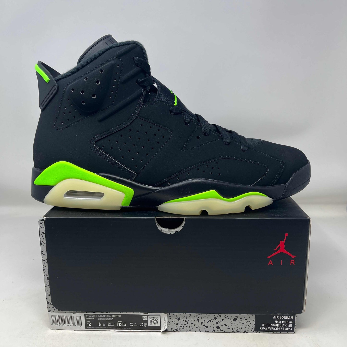 Black and electric green Jordan 6 Retro sneaker on a black Air Jordan shoebox