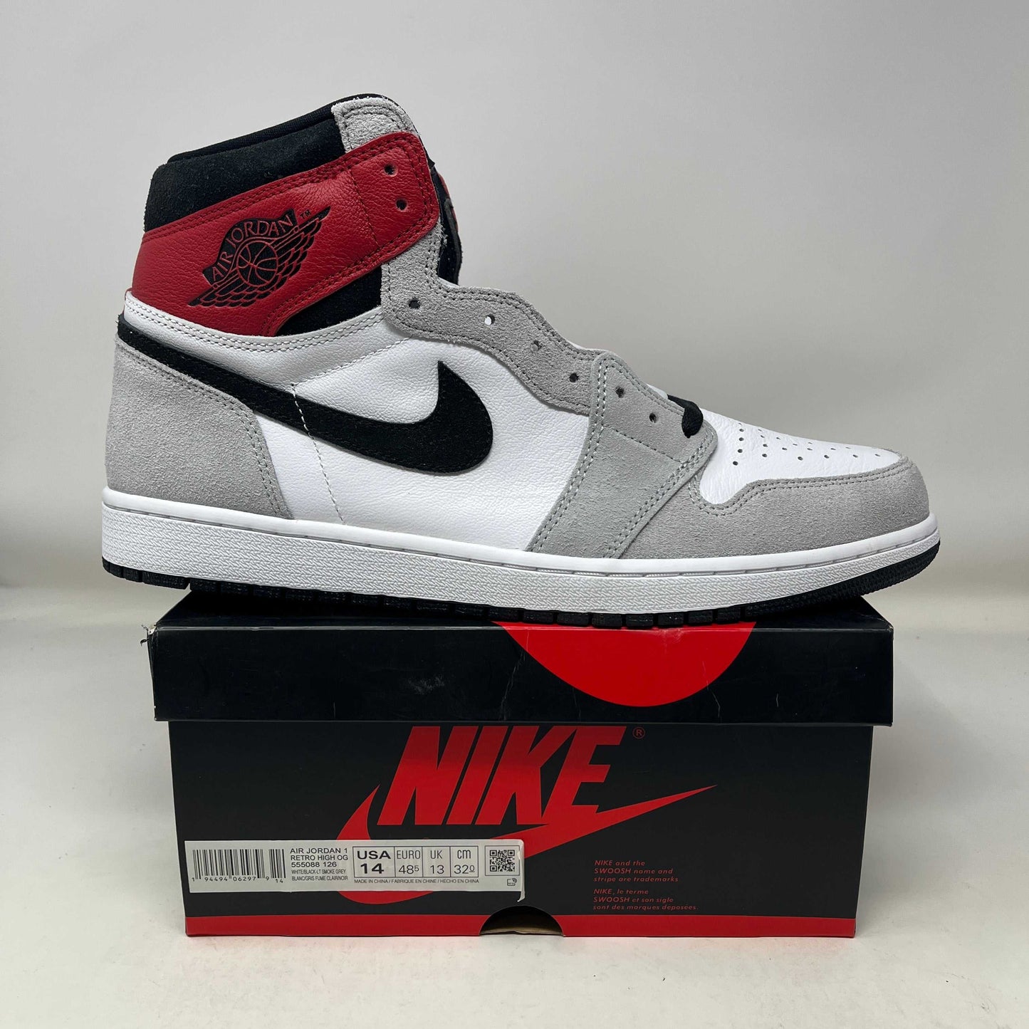 Jordan 1 Retro High Light Smoke Grey sneaker with red, black, white, and grey colors on Nike box