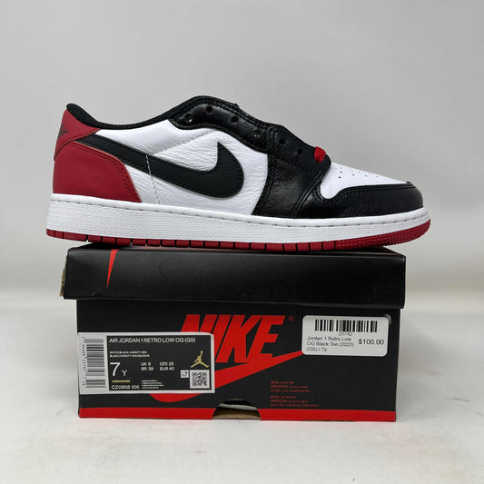 Jordan 1 Retro Low OG Black Toe sneaker in black, white, and red displayed on a Nike shoebox