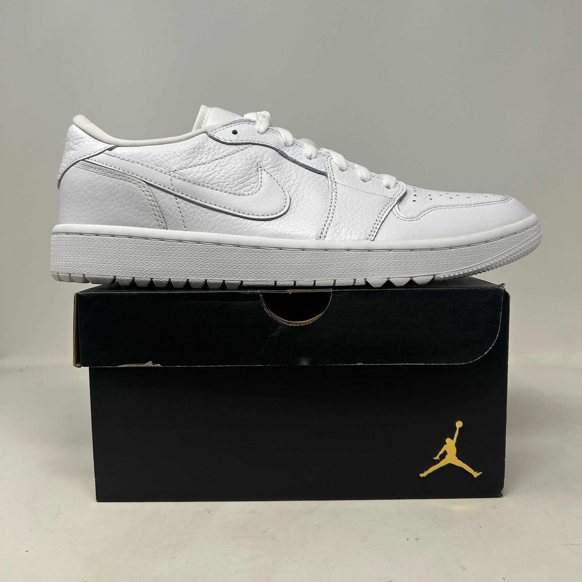 Jordan 1 Retro Low Golf sneaker in white leather, with a textured Swoosh, perforated toe and golf traction outsole.