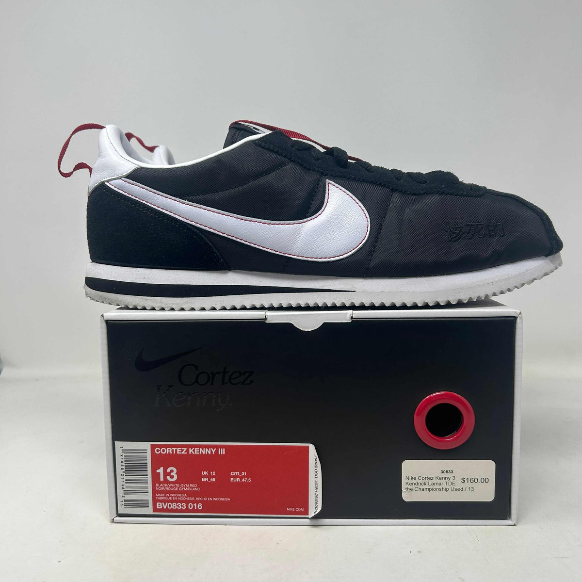 Nike Cortez Kenny 3 low-top sneaker with black mesh and leather, white Swoosh, red accents, and serrated sole.
