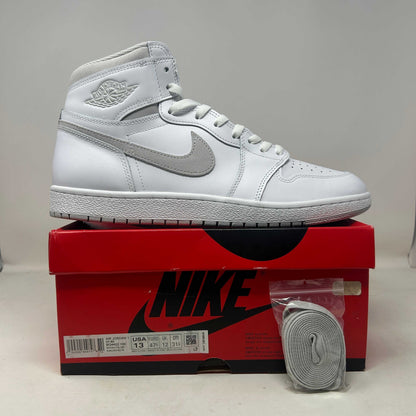 Jordan 1 Retro High '85 sneaker in white leather with grey Swoosh, laces and Wings logo, high-top design
