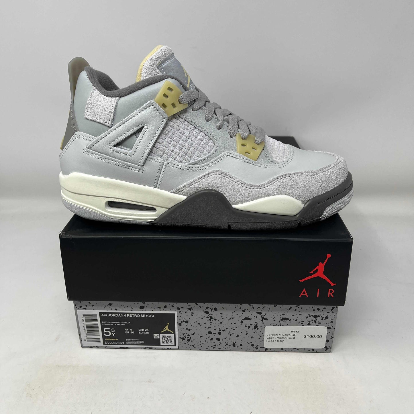 Jordan 4 Retro SE Craft Photon Dust GS sneaker in grey and cream colors on black Air Jordan box