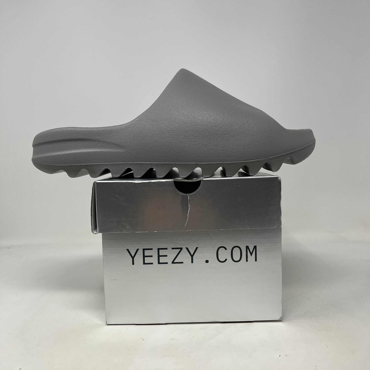 Grey molded foam YZY YS-01 Grey slide with a smooth, one-piece upper and distinctive ridged sole.