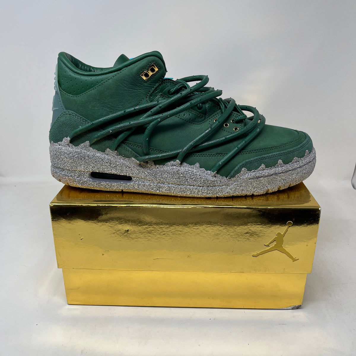 Jordan 3 Retro Teyana Taylor Concrete Rose sneaker in deep green leather with textured gray concrete-style sole and gold accents.